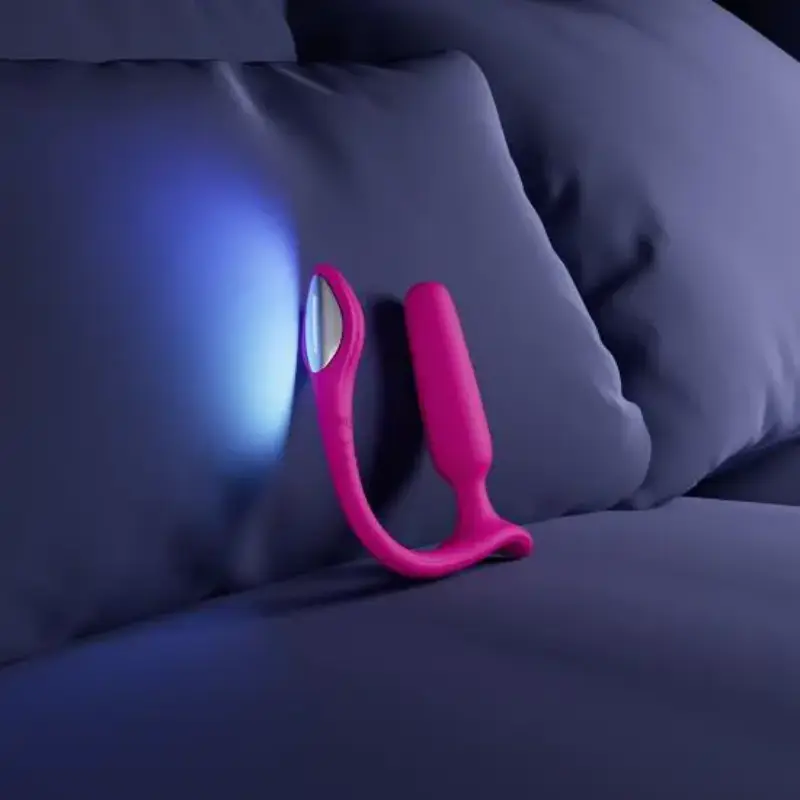 Plug anal Lovense Lush Anal com luzes LED ligadas em cima de uma cama